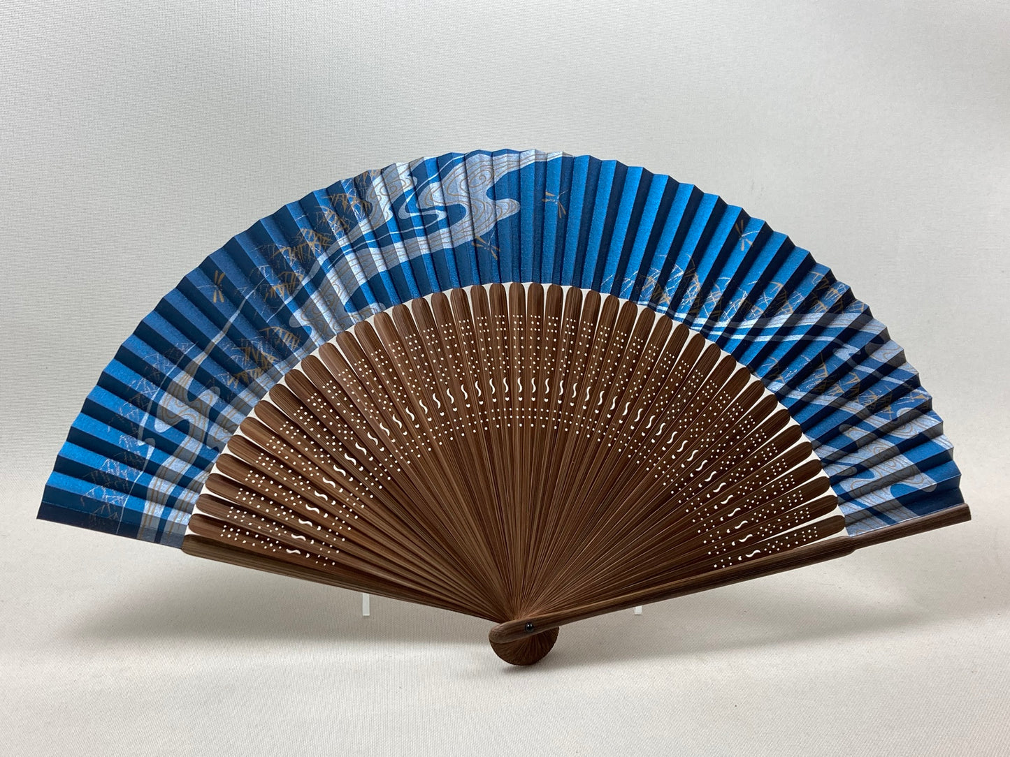 Navy fan with a picture of a flowing stream and dragonfly